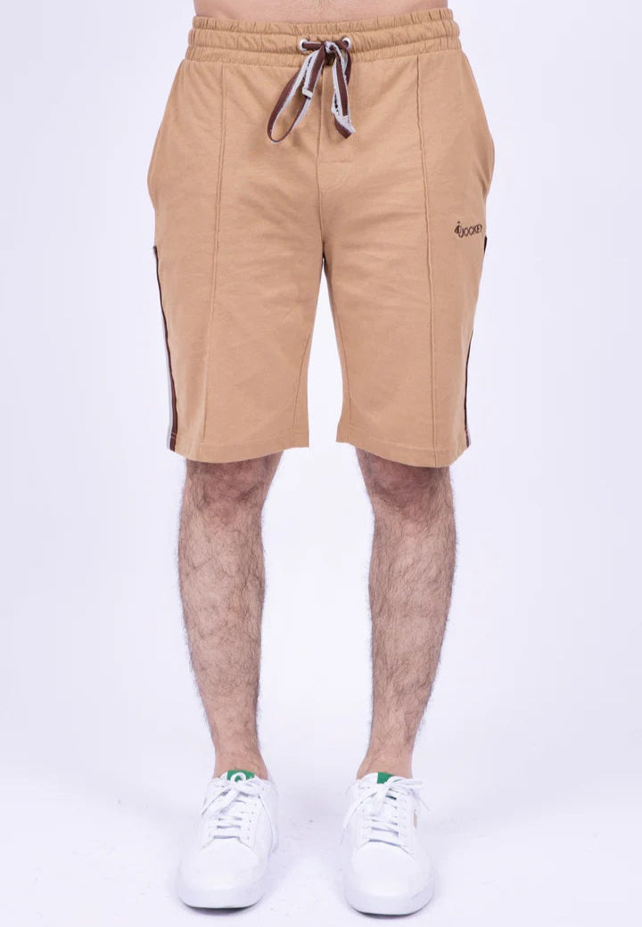 Beige shorts worn by a person on a white background